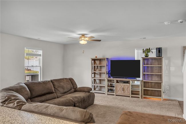 Living room with a ceiling fan, carpet floors, and baseboards | Image 5
