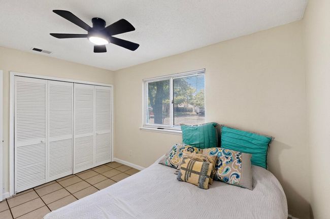 Bedroom with light tile patterned floors, a closet, and ceiling fan | Image 15