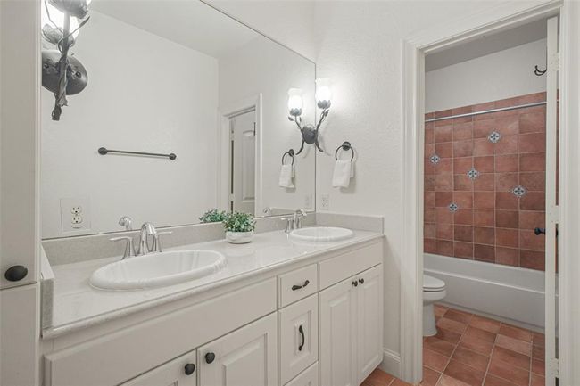 Charming upstairs bathroom with dual vanities and a tiled shower. | Image 36