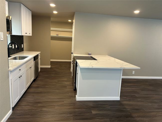 Kitchen featuring a sink, stainless steel appliances, baseboards, dark wood-style flooring, and recessed lighting | Image 16
