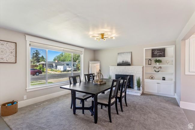 Dining room featuring a fireplace, a chandelier, and carpet | Image 14