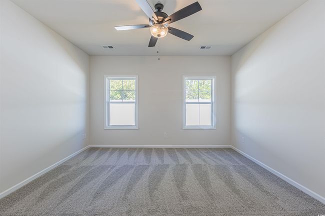 Spare room with visible vents, baseboards, carpet, and a ceiling fan | Image 12