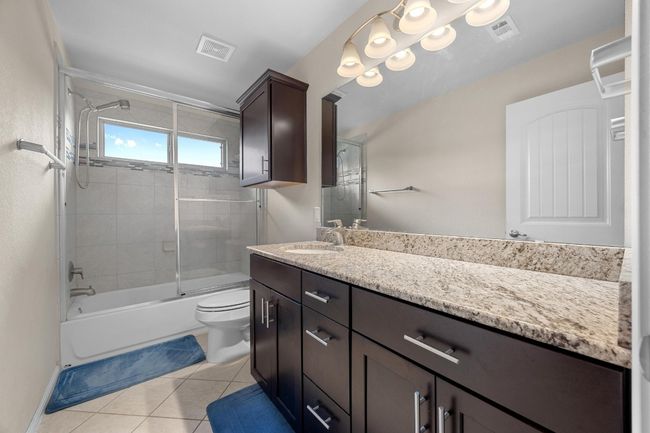The full secondary bathroom boasts a spacious granite topped vanity and a shower/tub combo. | Image 23