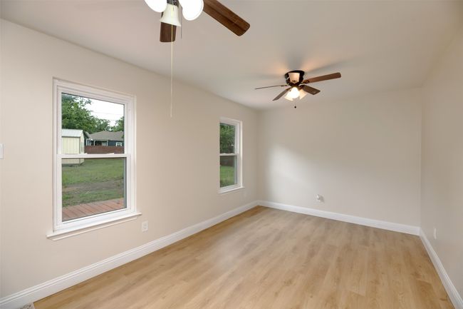 Empty room with ceiling fan, plenty of natural light, and light wood finished floors | Image 21