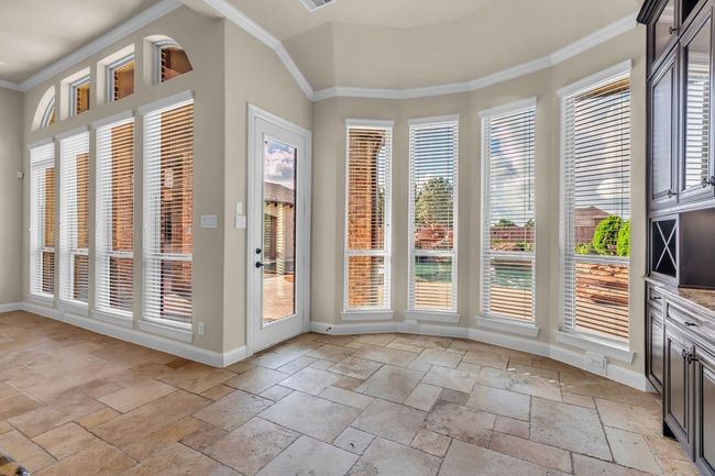 The bright breakfast area offers a cozy spot to enjoy morning meals, featuring large windows that provide a picturesque view of the backyard oasis. Natural light fills the space, creating a warm and inviting atmosphere perfect for starting the day. | Image 13