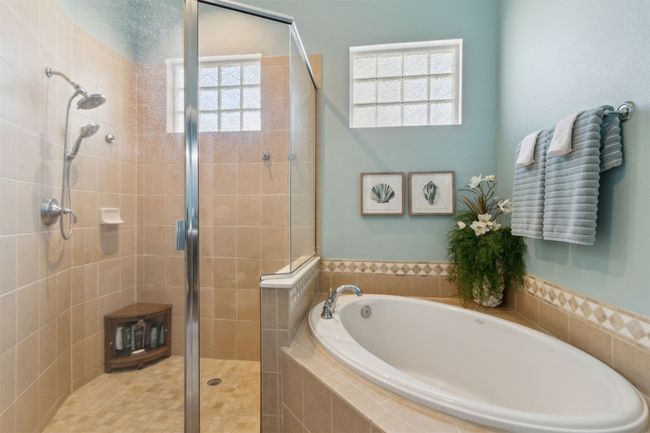 Features a soaking tub and tiled walk-in shower. | Image 17