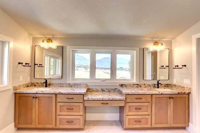 Full bathroom with marble look tiles, vanity, and a textured ceiling | Image 29