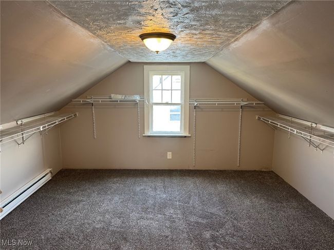 Bonus room featuring a baseboard radiator, lofted ceiling, and carpet flooring | Image 14