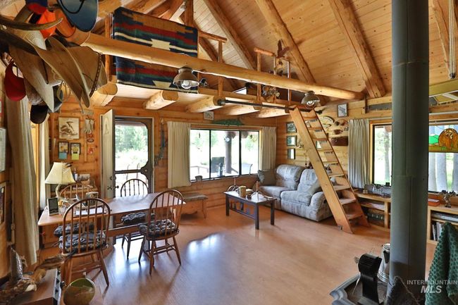 Dining area with wood walls, a wooden ceiling with exposed beams, plenty of natural light, wood finished floors, and high vaulted ceiling | Image 6