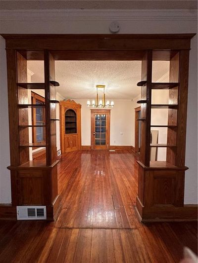 Hall featuring a textured ceiling and dark wood-type flooring | Image 2