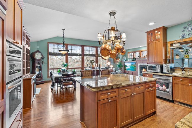 Kitchen viewed from hallway entry. Showing openness to breakfast bar, eating area and family room. Extra high ceilings and floor to ceiling windows overlooking the backyard and koi pond. | Image 5