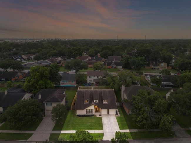 Aerial perspective showcases the generous lot size, long double driveway, and attached 2-car garage. The property is positioned in a quiet residential neighborhood, with a fully fenced backyard and convenient access to I-45, restaurants, shopping, and local amenities nearby. | Image 31