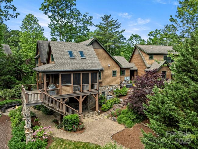 View of side yard that shows stone steps down from breezeway. Lower patio offers additional opportunity to entertain al fresco. Generator is outside the main level laundry room. Pea gravel pathways around the house and lot. | Image 42