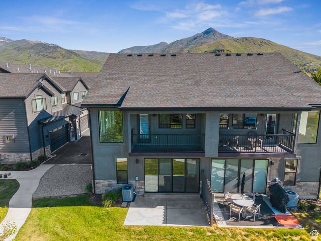 Rear view of property with a mountain view, stone siding, and a balcony | Image 48