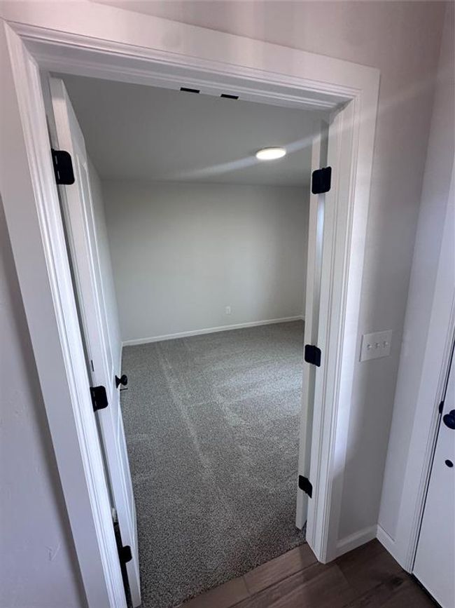 Corridor featuring baseboards and dark carpet | Image 4