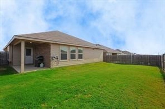 Rear view of house with a fenced backyard and a patio | Image 17