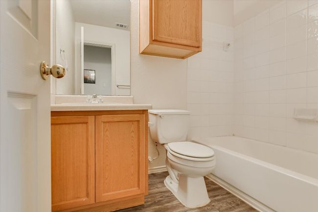 Bathroom with vanity, wood finished floors, and bathing tub / shower combination | Image 22