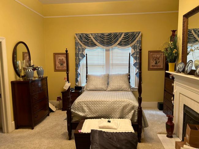 Carpeted bedroom with a tiled fireplace and ornamental molding | Image 4