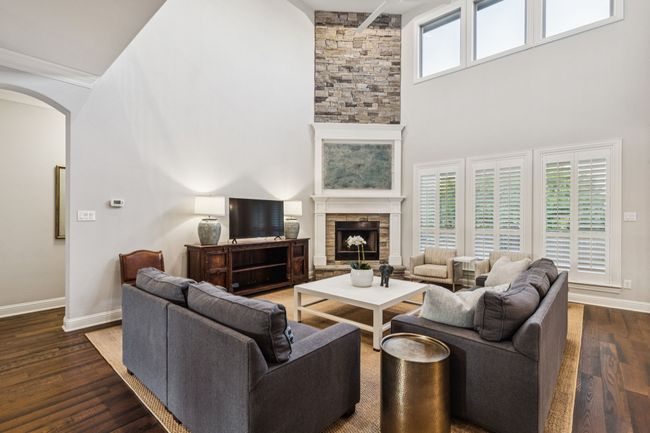 Living room with soaring ceilings, premium 60" fan and floor to ceiling stone fireplace | Image 10