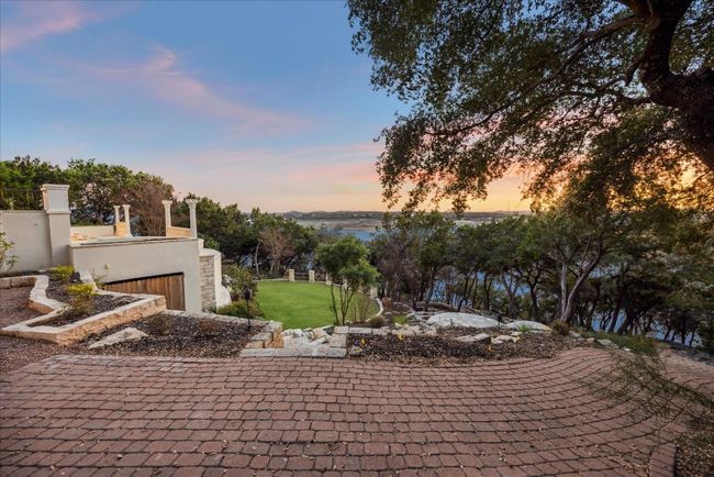 The rear yard offers a pool and spa, waterfall with multiple drops, grassy area, two charming bridges and stairs to the lake. | Image 40