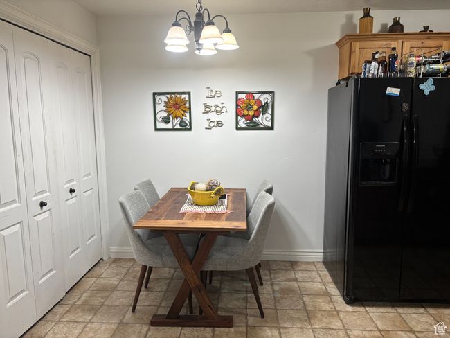 Dining room with stone finish floors, baseboards, and a chandelier | Image 11