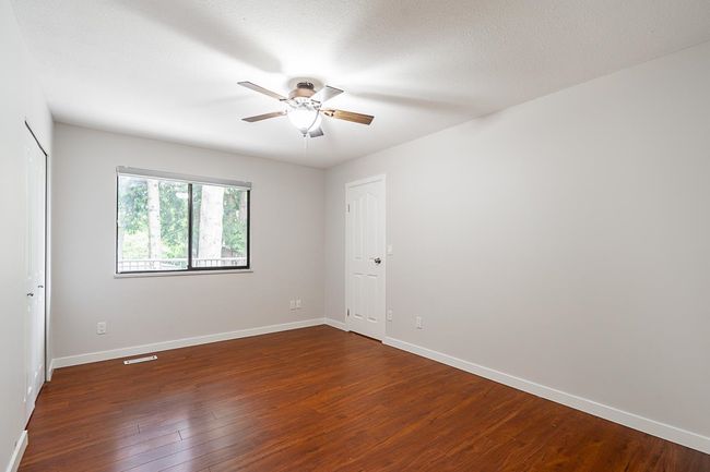 Unfurnished room with ceiling fan and dark wood-style flooring | Image 13