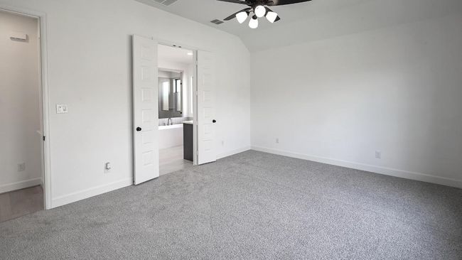 Unfurnished bedroom featuring light carpet, ensuite bath, and ceiling fan | Image 20