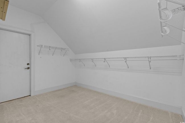 Spacious closet with lofted ceiling and light carpet | Image 35