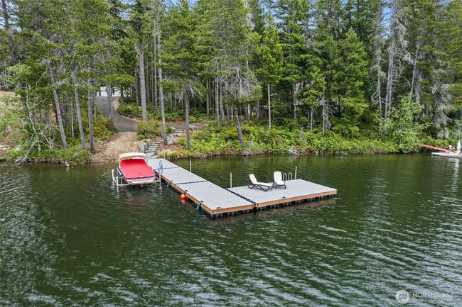 This is a view of the property from the lake looking up to the garage. The designated home building site is the first open space as you walk up from the dock. | Image 10