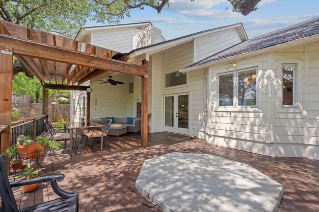 View of patio with ceiling fan, a wooden deck, an outdoor hangout area, french doors, and outdoor dining space | Image 34