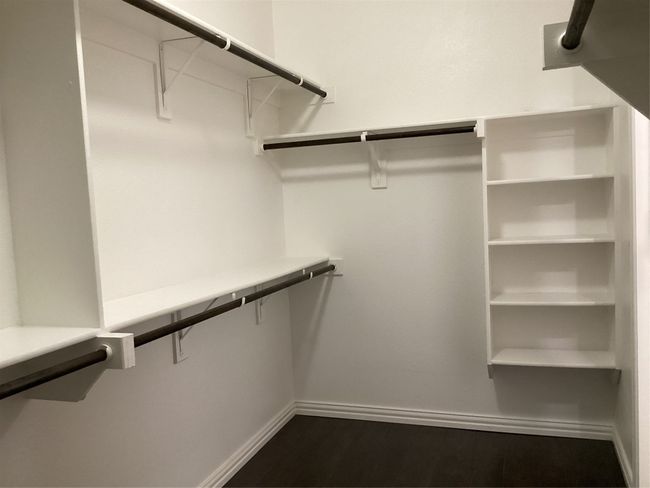 Spacious closet featuring dark wood finished floors | Image 16