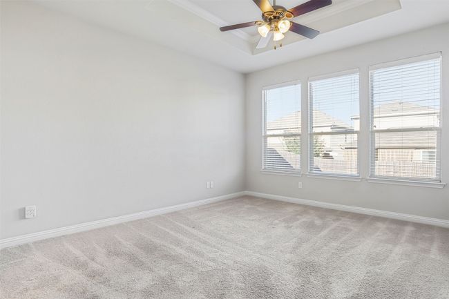 Spare room with light colored carpet, a raised ceiling, crown molding, and ceiling fan | Image 17