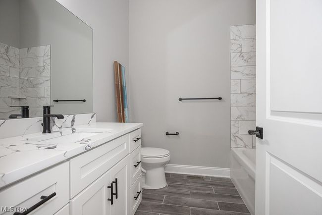 Full bathroom with tile floors, vanity, tiled shower / bath combo, and toilet | Image 24