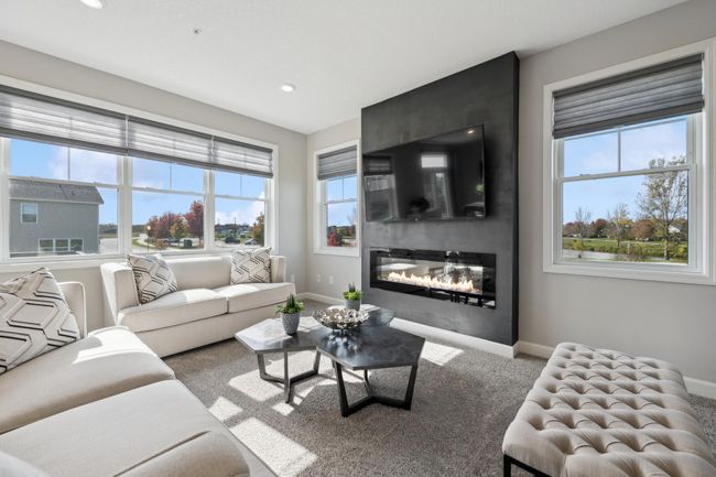 (Photo of decorated model, actual home's finishes will vary) Soaring windows provide an abundance of natural light to low throughout the main level, including this nicely sized great room, featuring an electric fireplace. | Image 10