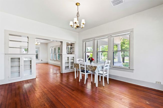 Dining area with a chandelier, healthy amount of natural light & wood flooring | Image 9