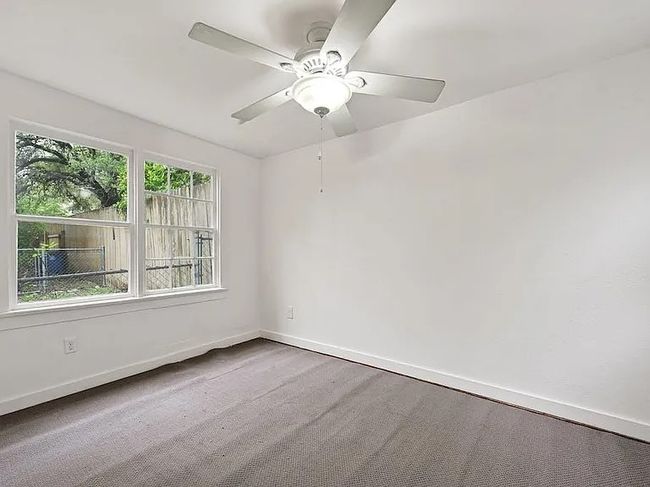 Carpeted empty room with a ceiling fan and baseboards | Image 13