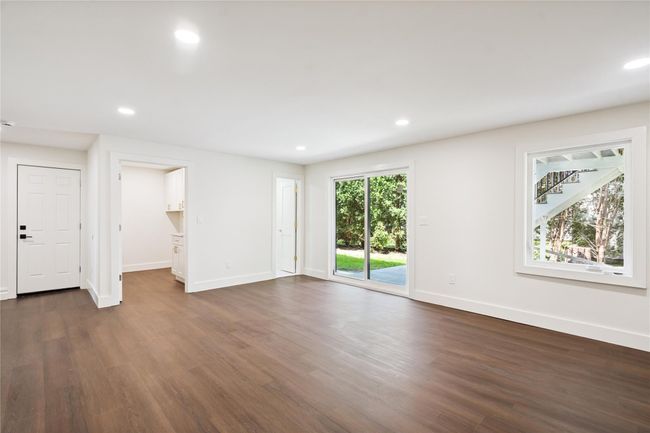 Unfurnished living room with dark wood-style floors and recessed lighting | Image 33