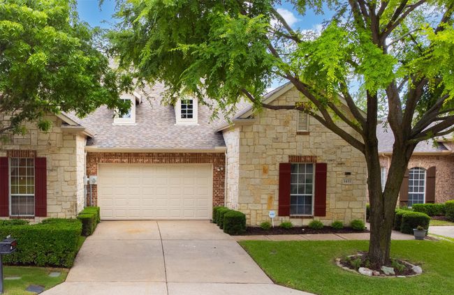 View of front of house featuring roof with shingles, driveway, stone siding, and a front yard | Image 35