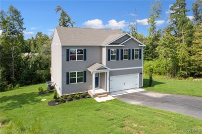 View of front facade with a front yard and a garage | Image 1