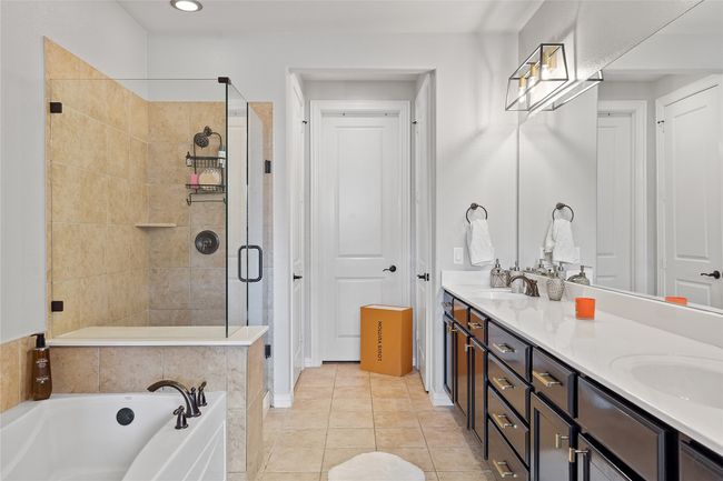 Full bathroom with a sink, double vanity, tile patterned floors, a stall shower, and a garden tub | Image 5