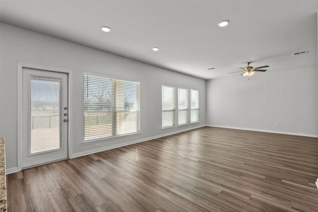 Unfurnished living room featuring a ceiling fan, wood-look tile floors, and recessed lighting | Image 7