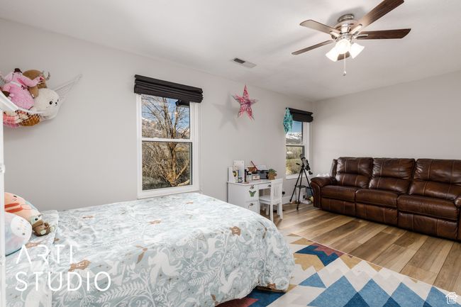 Bedroom featuring a ceiling fan, wood finished floors, and visible vents | Image 21