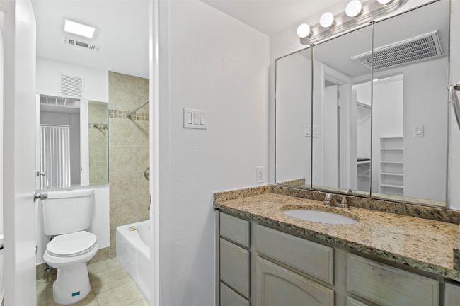 Downstairs ensuite bathroom featuring granite counters, custom tile shower/bath decorative lighting and walk in closet. | Image 11