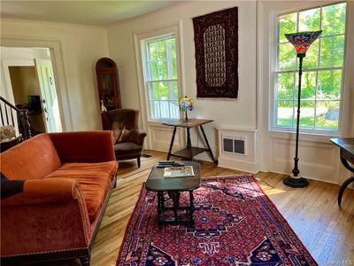 Living room with a healthy amount of sunlight, hardwood / wood-style floors, and crown molding | Image 3