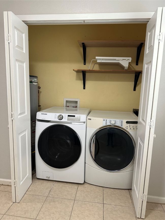Washroom with washer and clothes dryer and light tile patterned flooring | Image 13