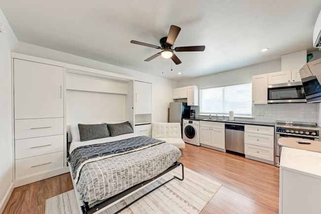 Bedroom featuring washer / clothes dryer, light wood-type flooring, recessed lighting, freestanding refrigerator, and a ceiling fan | Image 6