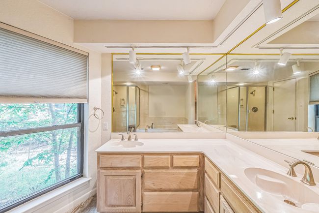 Full bath featuring double vanity, a stall shower, and a sink | Image 27