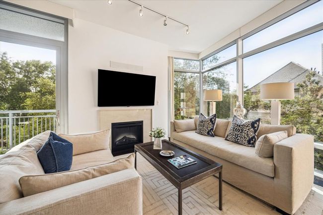 This view shows living area with the electric fireplace and looking out onto the tree lined views | Image 7