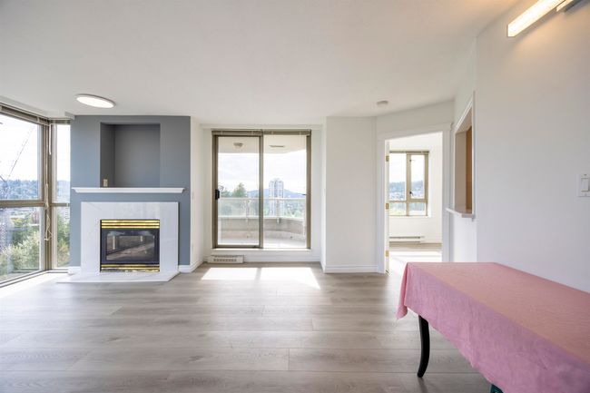 Living room featuring wood finished floors, a fireplace, baseboard heating, and floor to ceiling windows | Image 15