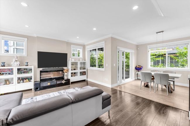 Living area with wood finished floors, ornamental molding, and recessed lighting | Image 4